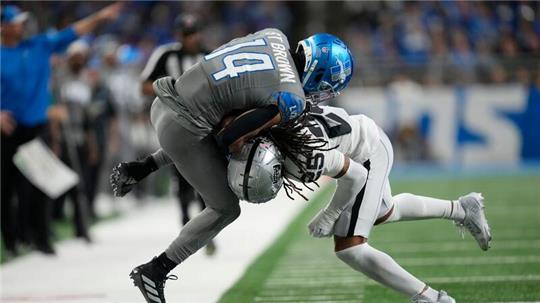 Detroit Lions Wide Receiver Amon-Ra St. Brown (14) wird von Las Vegas Raiders Safety Tre’von Moehrig (25) aus dem Spielfeld gedrängt.