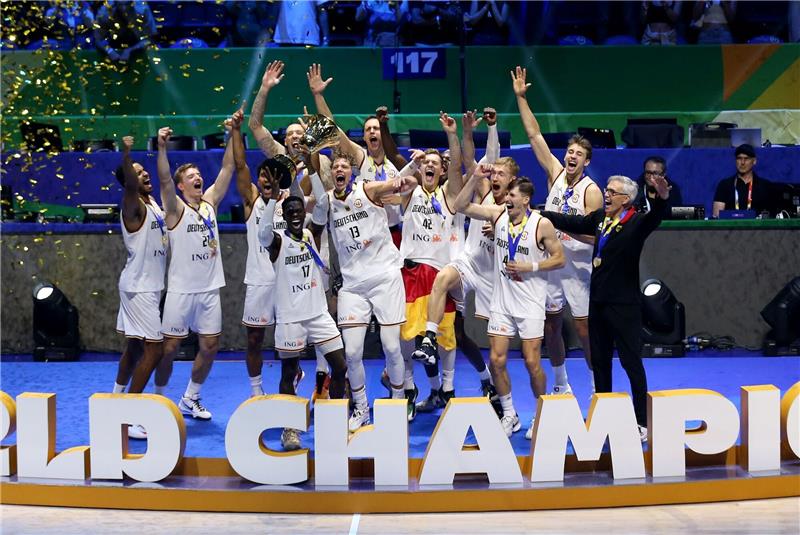 Respekt bekommen in Deutschland war große Motivation Deutschlands Dennis Schröder (4.vl) hebt den Pokal bei der Siegerehrung hoch und feiert mit dem Team den WM-Titel.