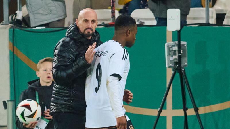 Deutschlands U21-Bundestrainer Antonio Di Salvo (l) wechselt Youssoufa Moukoko aus.