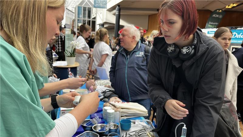 Werben um Azubis: Wenn Top Gun plötzlich im Stadeum auftaucht Die 15-jährige Sophie von der IGS Buxtehude lässt sich von Johanna Burfeindt vom Elbe Klinikum einige medizinische Instrumente erklären.