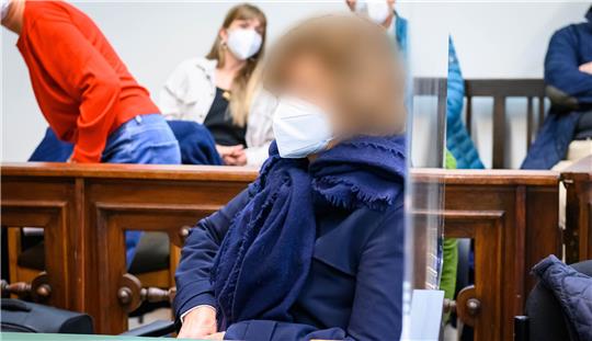 Die 60-Jährige Angeklagte (M) sitzt vor Beginn der Verhandlung im Gerichtssaal. Prozessauftakt wegen Freiheitsberaubung gegen eine 60-Jährige, die mit Komplizen ihren pflegebedürftigen Geliebten entführt haben soll. Foto: Jonas Walzberg/dpa