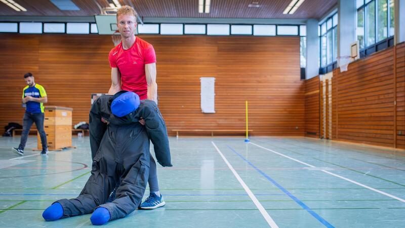 Die 80 Kilogramm schwere Sandpuppe musste in 45 Sekunden quer durch die Sporthalle gezogen und auf eine blaue Matte transportiert werden.