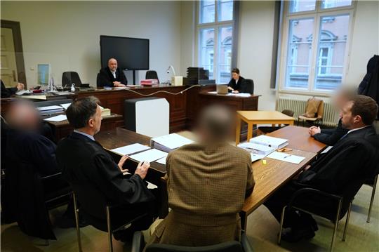 Die Angeklagten (l, M, und hinten r) sitzen mit ihren Anwälten zu Beginn des Prozesstages wegen Gefährdung des Schiffsverkehrs im Sitzungssaal im Strafjustizgebäude. Foto: Marcus Brandt/dp