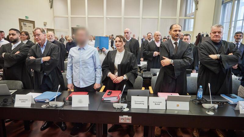Prozess um millionenschweren Diebstahl der „Edelmetall-Bande“ aus Kreis Stade gestartet Die Angeklagten und ihre Anwälte stehen im Gerichtssaal vor Beginn des Prozess gegen eine mutmaßliche Diebesbande, die insgesamt zwölf Straftaten zum Nachteil des Unternehmens Aurubis verübt haben soll.