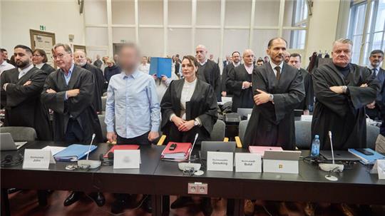Die Angeklagten und ihre Anwälte stehen im Gerichtssaal vor Beginn des Prozess gegen eine mutmaßliche Diebesbande, die insgesamt zwölf Straftaten zum Nachteil des Unternehmens Aurubis verübt haben soll.
