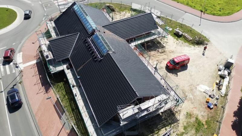 Die Aufnahme zeigt das neue Gebäude in Kreuzform noch während der Bauarbeiten. Jetzt ist alles fertig - es darf gefeiert werden.