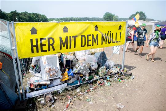 Die Aufschrift „Her mit dem Müll!“ steht an einem Sammelplatz für Müll auf dem Zeltplatz des Hurricane Festivals 2022. Foto: Dittrich/dpa
