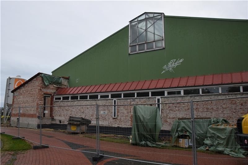 Die Baufortschritte sind von außen zu erkennen – der alte rote Klinker an der Fassade der Sporthalle Striep in Steinkirchen ist bereits ab. Foto: Battmer