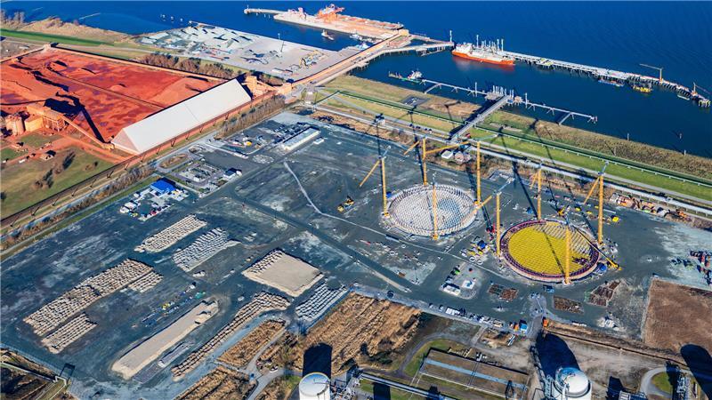Die Baustelle für das LNG-Terminal in Stade-Bützfleth. Gut zu erkennen die runden Fundamente für die Gasspeicher. Links die rote Erde von der AOS, oben der Hafen direkt an der Elbe.