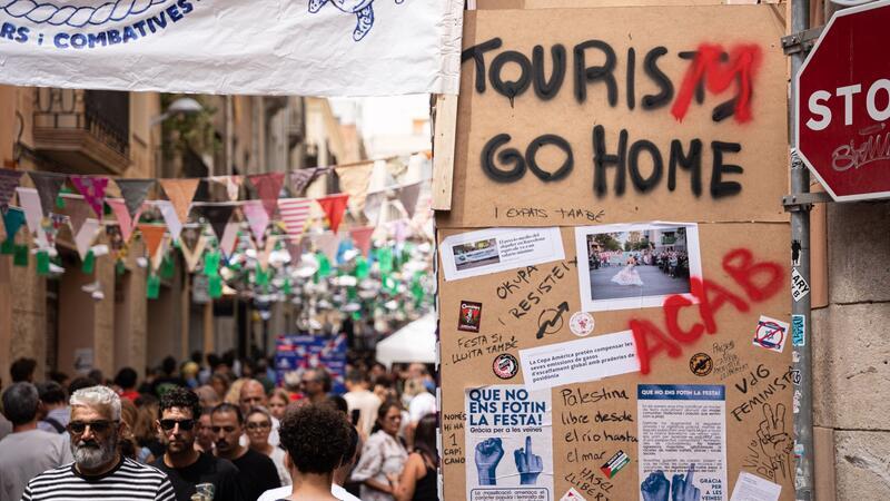 Tui-Chef will Tourismus-Proteste auf Mallorca ernst nehmen Die Botschaft an Touristen ist deutlich, auch hier bei einem Straßenfest in Barcelona.