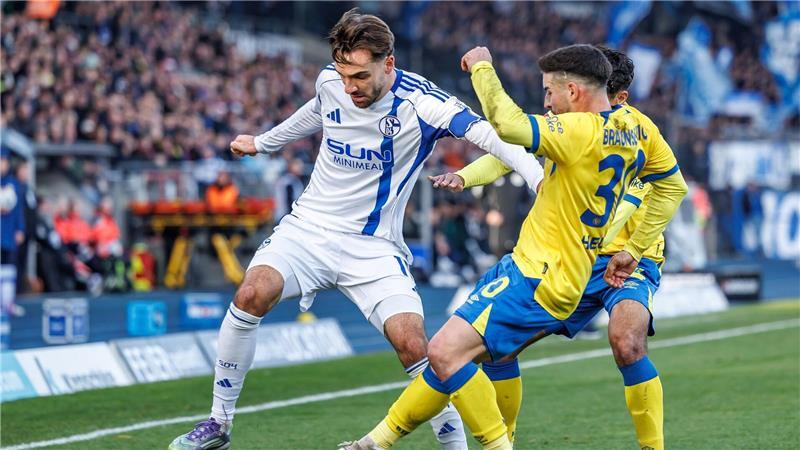 Die Braunschweiger Johan Gomez (verdeckt, Eintracht Braunschweig) und Robin Heußer bedrängen den Schalker Kenan Karaman (l).