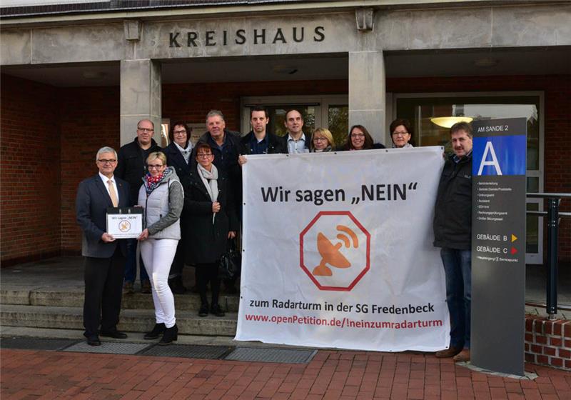 Die Bürgerinitiative übergibt die Unterschriftenlisten vor dem Kreishaus an Landrat Michael Roesberg. Foto: Beneke