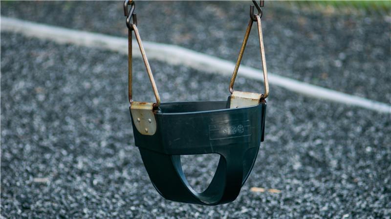 Eine Babyschaukel auf einem Spielplatz.