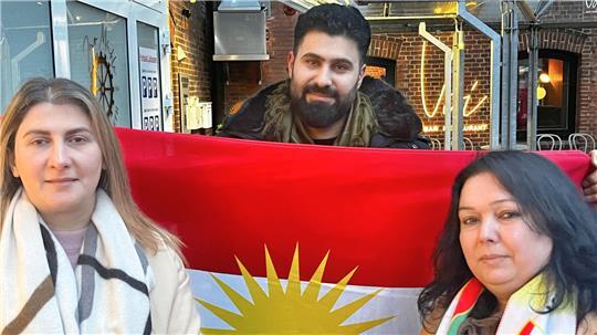 Die Buxtehuder Silava Mahmoud, Mohamed Youssef und Mona Mohamad mit der Flagge Kurdistans.