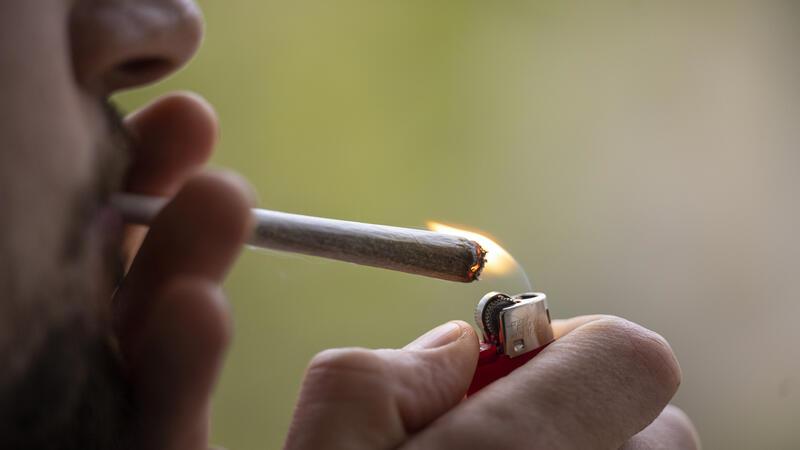 Mein Kind kifft: Was tun? Ein Mann zündet sich einen Joint an.