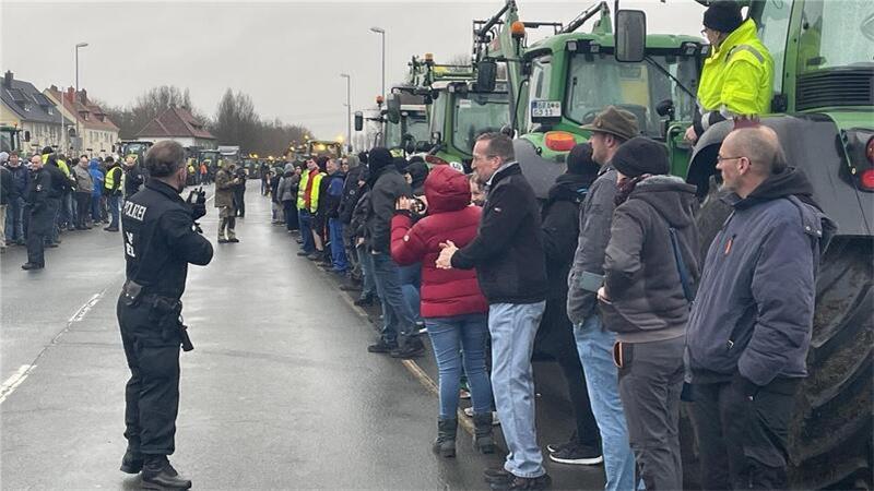 Die Demonstranten bilden vor ihren Traktoren ein Spalier für den Minister. Polizisten gewährleisten die Sicherheit aller Beteiligten.