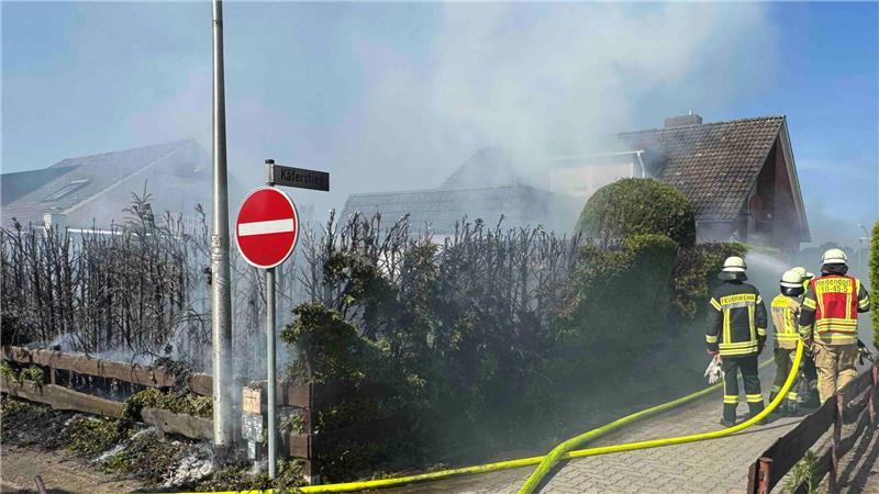 Die Einsatzkräfte der Ortswehr löschen einen Heckenbrand in Buxtehude-Hedendorf.