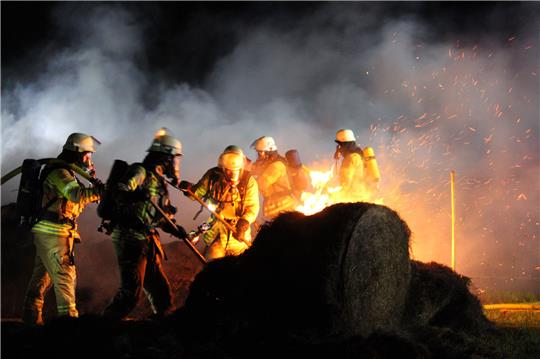 Die Einsatzkräfte mussten die Heuballen auseinander reißen. Fotos: Rolf Hillyer-Funke/Feuerwehren Samtgemeinde Oldendorf-Himmelpforten