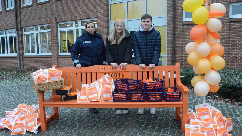 „Manchmal sehen wir Anzeichen und sprechen die Schüler direkt an“ Die FSJler Johanna Stuppin und Matti Meyn haben die Bank mit Schülern orange angemalt. Sie bleibt als Erinnerungsstütze auf dem Pausenhof, was auch Tanja Bett (links) von der Polizei unterstützt.