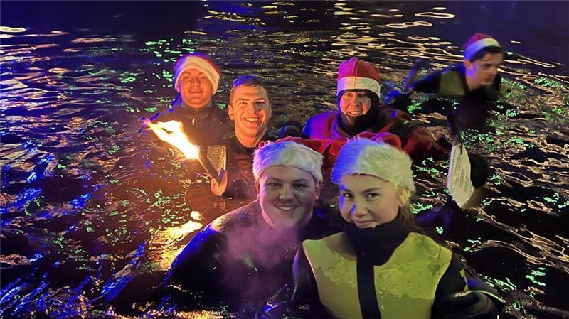 Stade: Fackelschwimmer stürzen sich am Fischmarkt ins kalte Wasser Die Fackelschwimmer sangen Weihnachtslieder im vier Grad kalten Wasser im Hafenbecken am Fischmarkt.