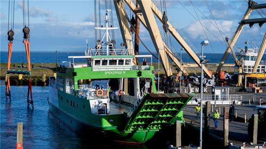 Die Fähre „Spiekeroog IV“ liegt im Hafenbecken, nachdem der Schwimmkran „Enak“ das Schiff von einer Parkfläche ins Wasser gehoben hat. Das 300 Tonnen schwere Schiff, das im Fährverkehr zur ostfriesischen Insel Spiekeroog eingesetzt wird, hatte sich während des Sturmtiefs „Zoltan“ im Dezember 2023 vom Liegeplatz und war auf eine Parkfläche im Hafen getrieben. 