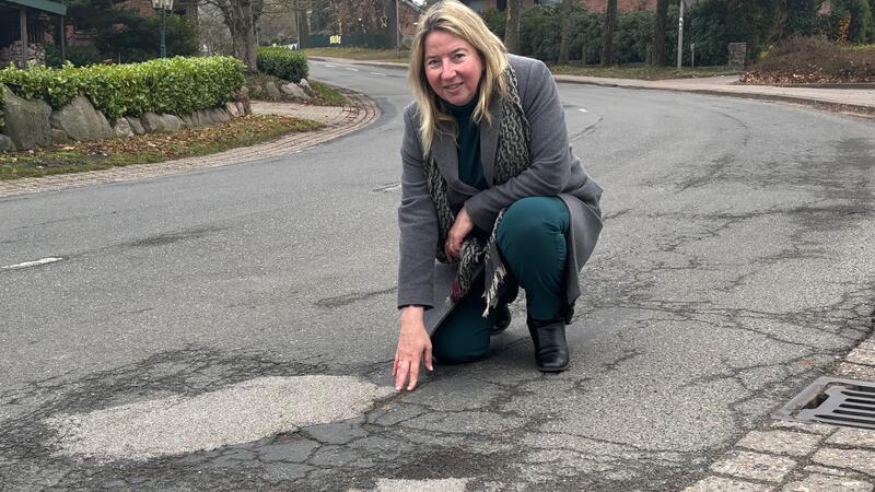 Die Fahrbahn der Harsefelder Straße (K26) in Hedendorf ist in schlechtem Zustand: Ortsbürgermeisterin Birgit Butter (CDU) zeigt Fahrbahnschäden in Höhe des Dorfgemeinschaftshauses.