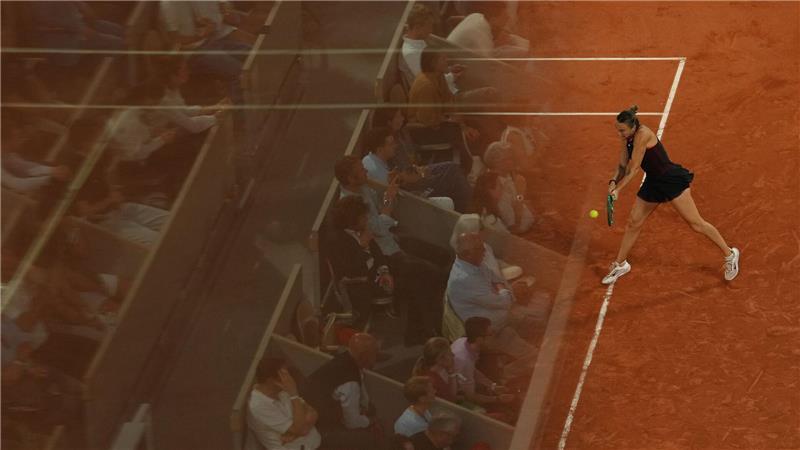 Die Fans spiegeln sich in einer Glaswand bei den French Open, während Aryna Sabalenka eine Rückhand gegen Naomi Osaka spielt.