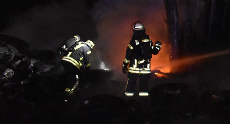 Die Feuerwehr hatte den Reifen-Brand schnell unter Kontrolle, immer wieder schlagen Flammen bei den Löscharbeiten hoch. Foto: Vasel