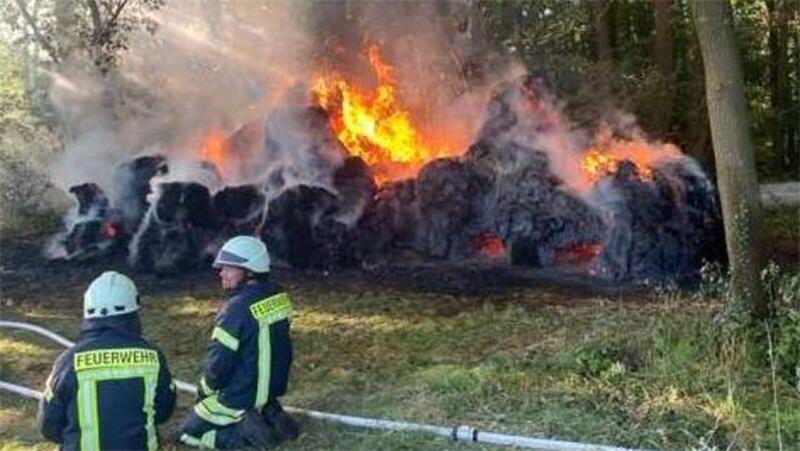 Heuballen stehen in Flammen - war es Brandstiftung? Die Feuerwehr konnte verhindern, dass das Feuer von den Strohballen auf den Wald übergreift.