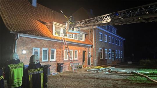 Die Feuerwehr kontrolliert aus der Drehleiter das Dach, um auszuschließen, dass sich das Feuer dorthin ausgebreitet hat.