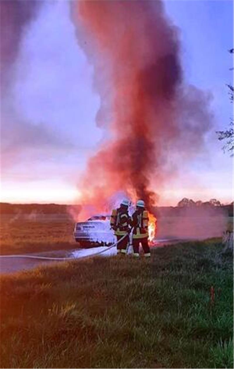 Die Feuerwehr löscht das brennende Auto mit einem Schaumangriff ab.