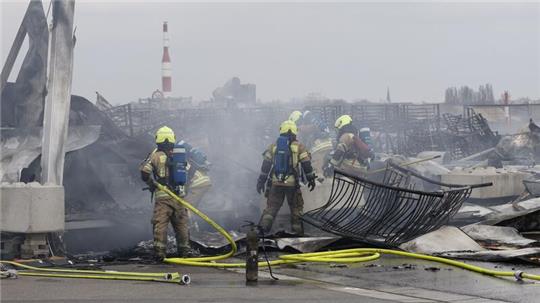 Die Feuerwehr löscht die Brandstelle bei der Flüchtlingsunterkunft am ehemaligen Flughafen Tegel. Die Nachlöscharbeiten sind inzwischen abgeschlossen.