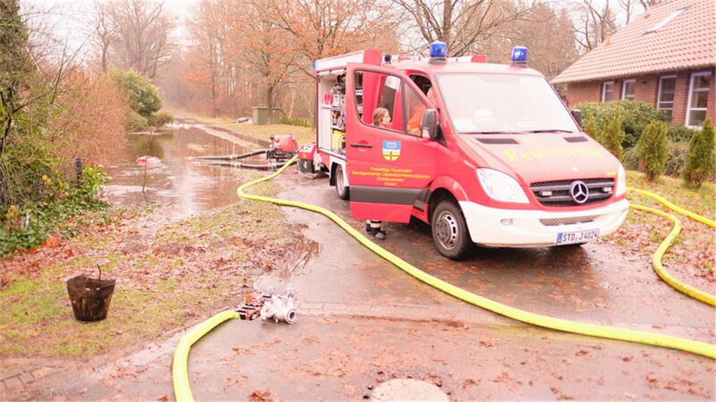 Die Feuerwehr pumpt in Estorf Wasser aus einem überlaufendem Regenrückhaltebecke...