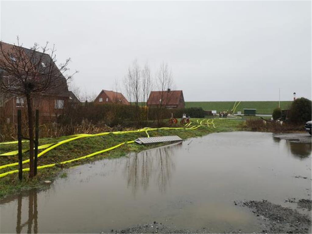 Die Feuerwehr pumpt in Jork-Borstel Wasser mithilfe von Schläuchen über den Deic...