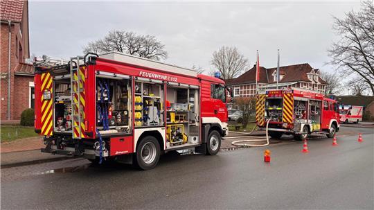Löschfahrzeuge der Feuerwehr stehen vor einem Wohnhaus in Heeslingen.