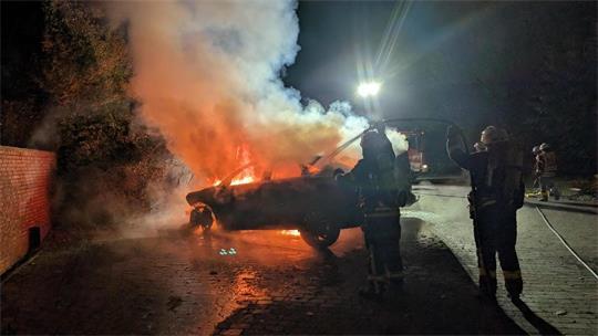Rauch und Flammen dringen aus einem Wagen.