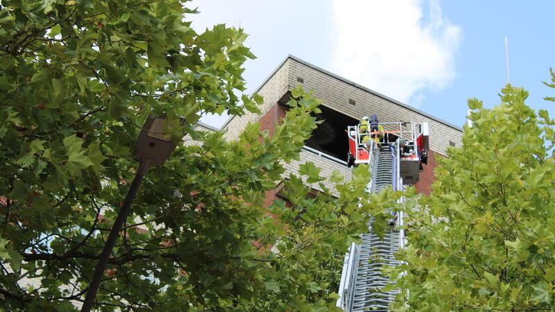 Die Feuerwehr überprüft die betroffene Wohnung mit der Drehleiter auf Brandnester.