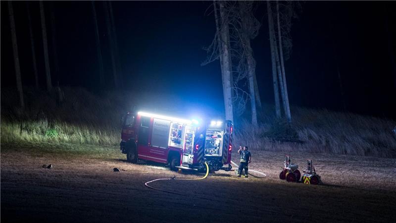 Die Feuerwehr überwacht am Waldrand Glutnester nach einem Waldbrand in einem Waldstück der Saalfelder Höhe.