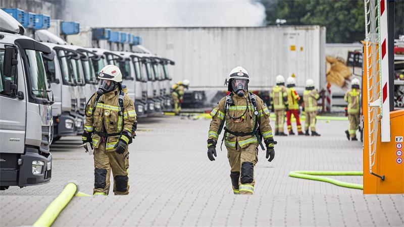 Die Feuerwehr versucht das Übergreifen der Flammen auf das Gebäude zu verhindern.