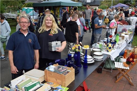 Die Feuerwehrleute Jörg Wiebusch und Svea Wandersee (vorne von links) sammeln bei den Flohmarkthändlern in Reith Spenden. Foto: Sulzyc