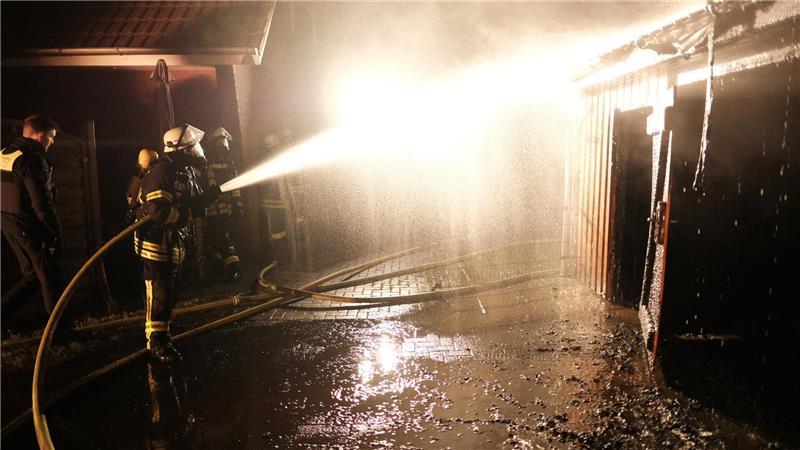 Die Feuerwehrleute bekämpfen den Brand von allen Seiten, um eine Ausdehnung auf Wohnhäuser zu verhindern.