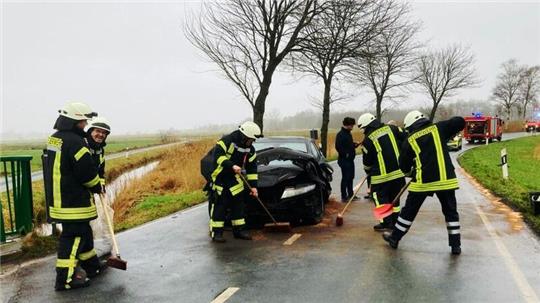 Die Feuerwehrleute kümmern sich um das Unfallauto.