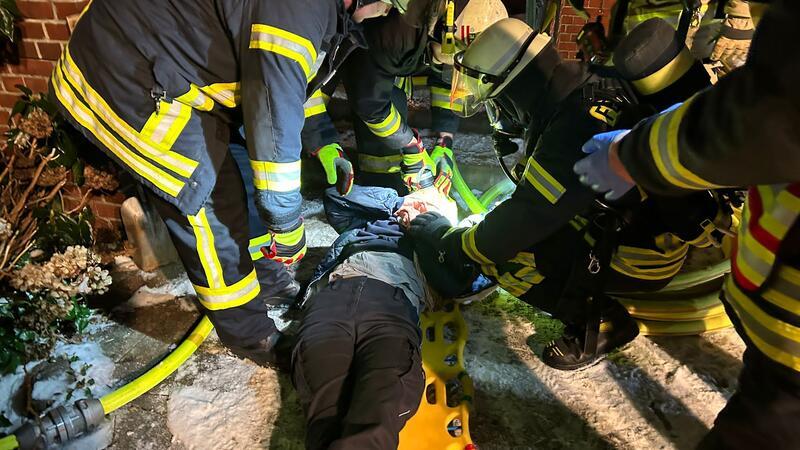 Hausbrand in Buxtehude - Feuerwehr übt den Ernstfall Die Feuerwehrleute kümmern sich um eine gerettete Person.
