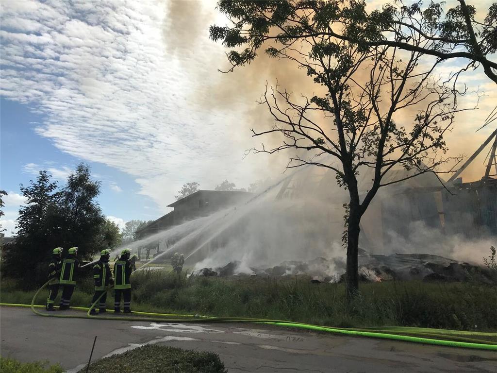 Die Feuerwehrleute versuchen, mit viel Wasser das Feuer zu löschen.