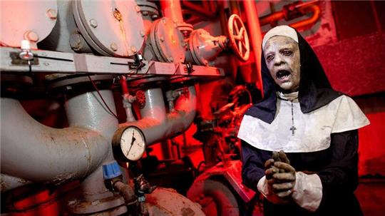 Die Figur einer Nonne steht im illuminierten Heizungskeller eines ehemaligen Busdepots, in dem die temporäre Attraktion „Das Spukhaus 2023“ aufgebaut wurde.