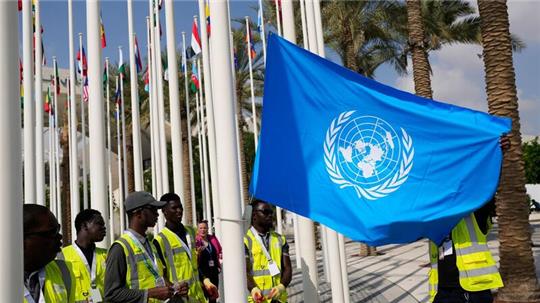 Die Flagge der Vereinten Nationen wird vor dem UN-Klimagipfel COP28 aufgehangen.