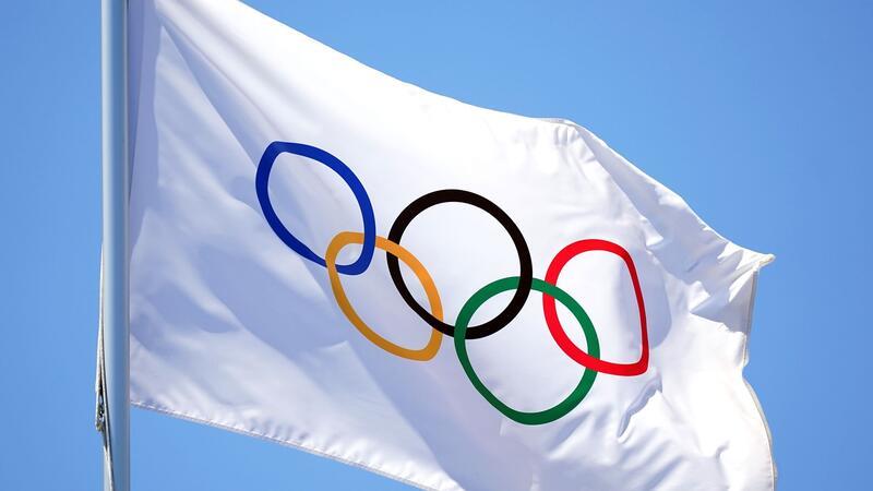 Die Flagge mit den olympischen Ringen weht im Wind.