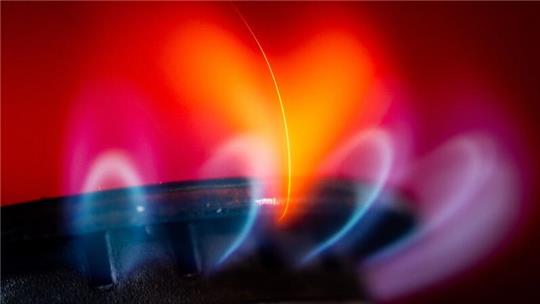 Die Flamme eines Gasherdes brennt in einer Küche.