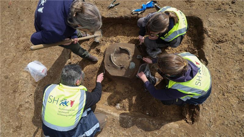Die Forscher stießen auf Fragmente eines Bronzekessels mit markanten Henkelansätzen und weitere Gefäßteile.
