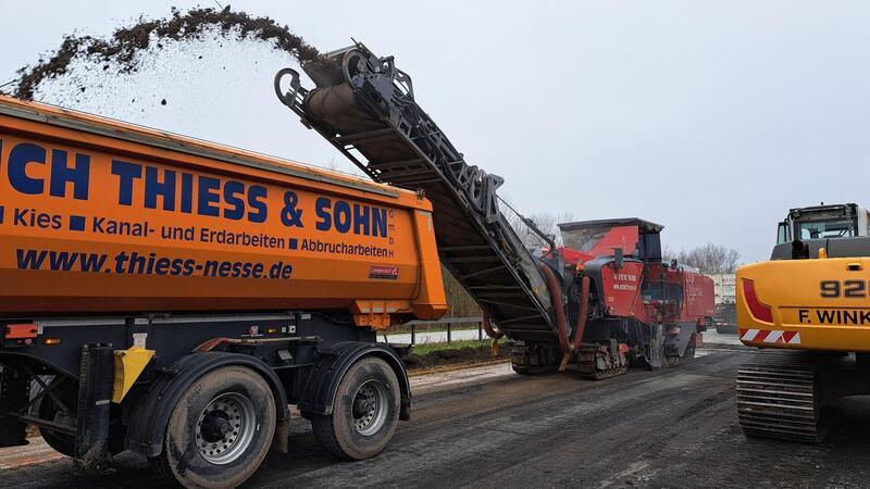 A27: Notsanierung begonnen, Termin für Freigabe genannt Die Fräse transportiert die zerkleinerte Fahrbahnreste über ein Förderband in einen Lastwagen.
